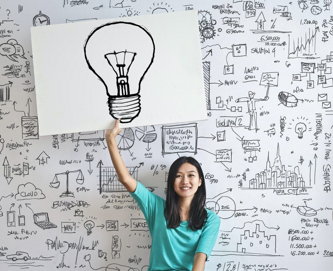 Woman Draw a Light bulb in White Board